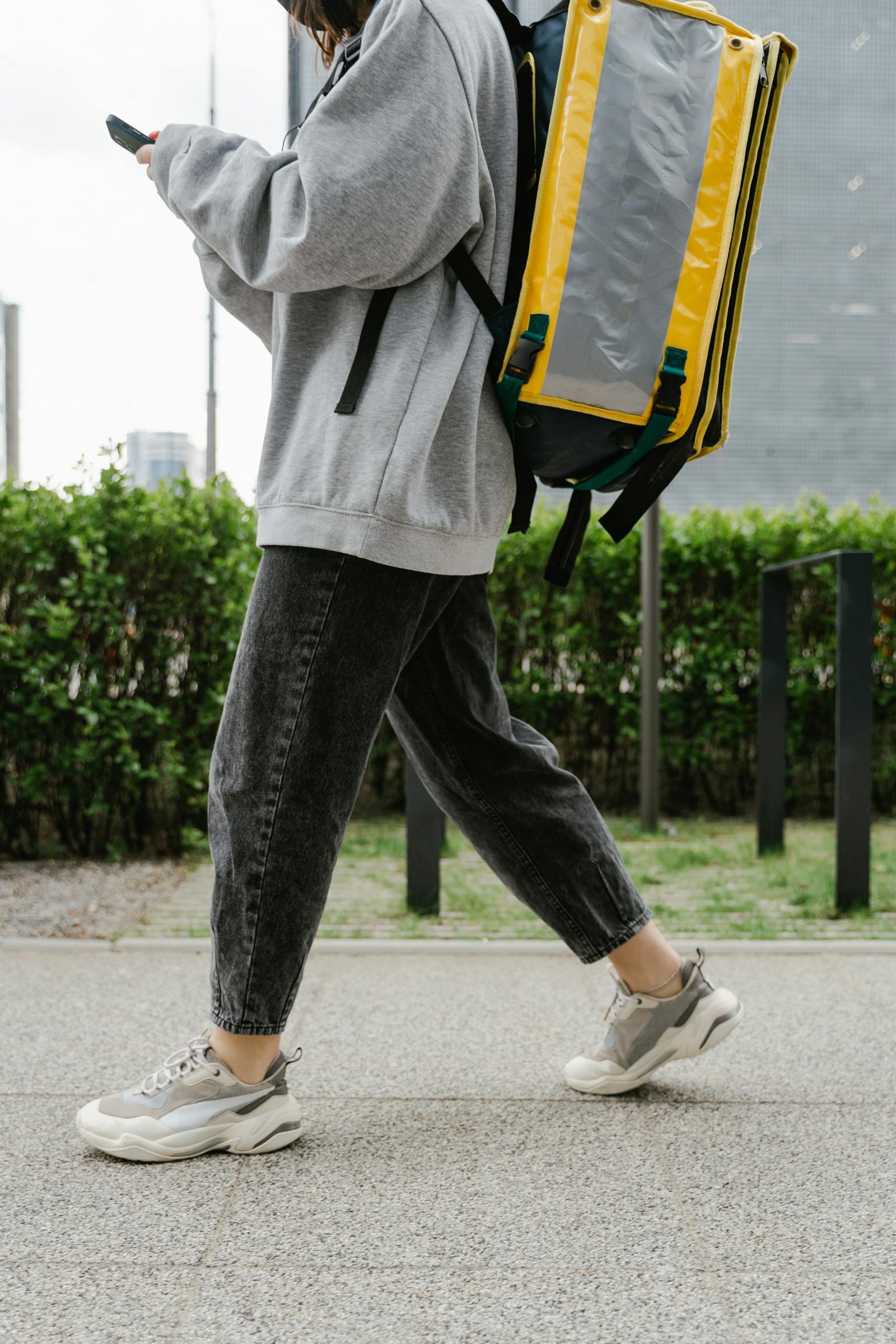 Courier walking with a food delivery backpack in the city.